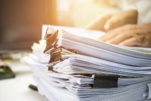 Businessman hands searching information in Stack of papers files