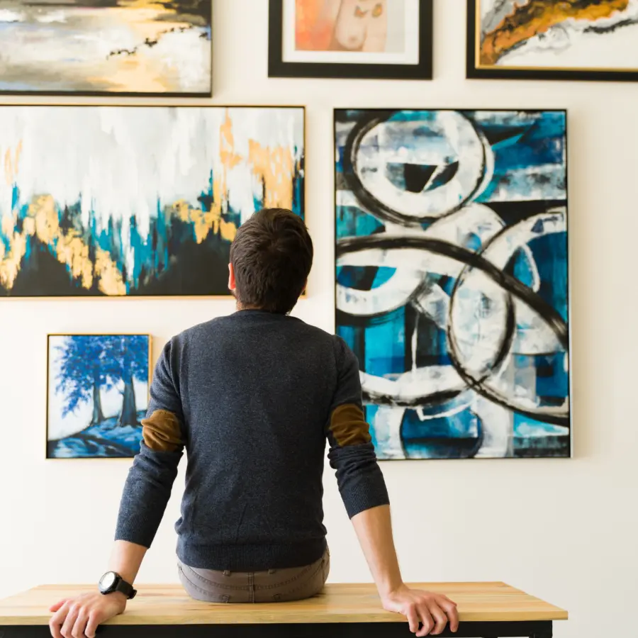 Rear view of a guy in his 30s looking at an art exhibition