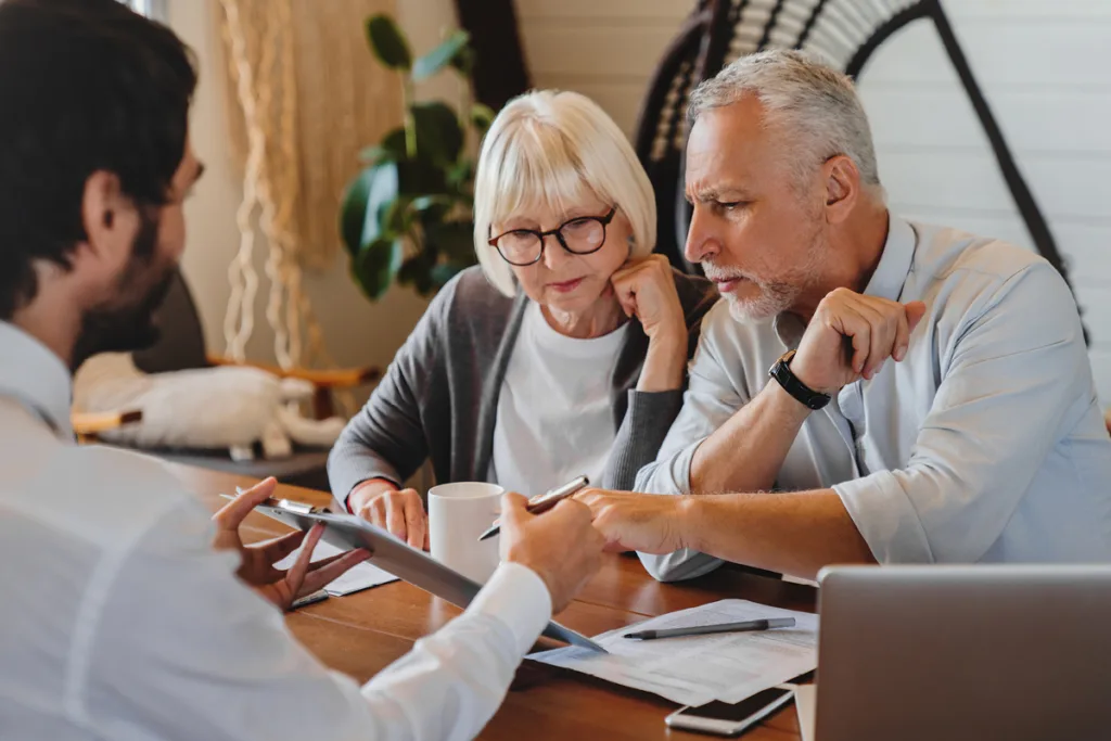 People sitting at a table looking over paperwork symbolizing Beneficiary Account with No Designation